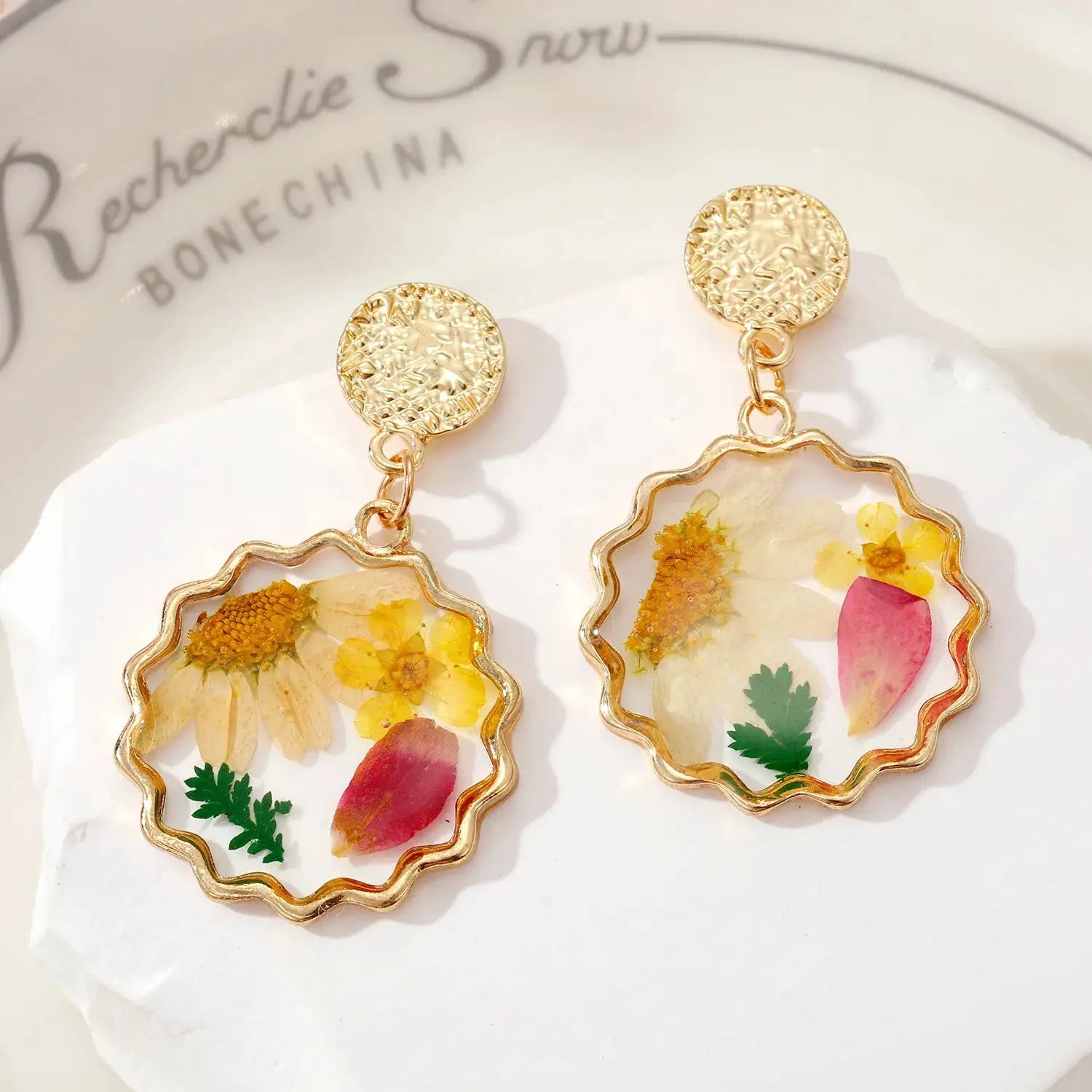 Pair of gold-tone epoxy resin pressed-flower dangle earrings with scalloped frames