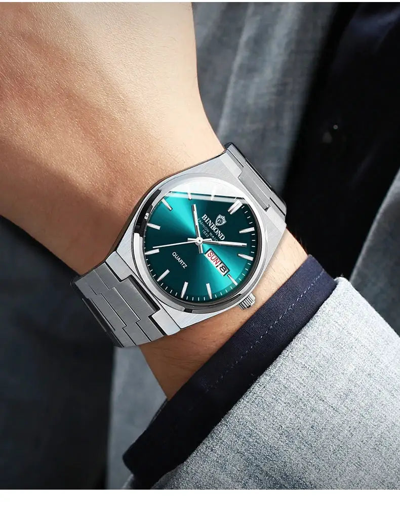 BINBOND men's stainless steel wristwatch with teal dial, day-date window, silver bracelet, quartz movement