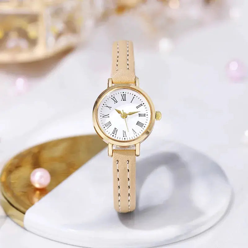 Women's leather strap watch by Simples Market with beige band, gold-tone case, Roman numeral dial