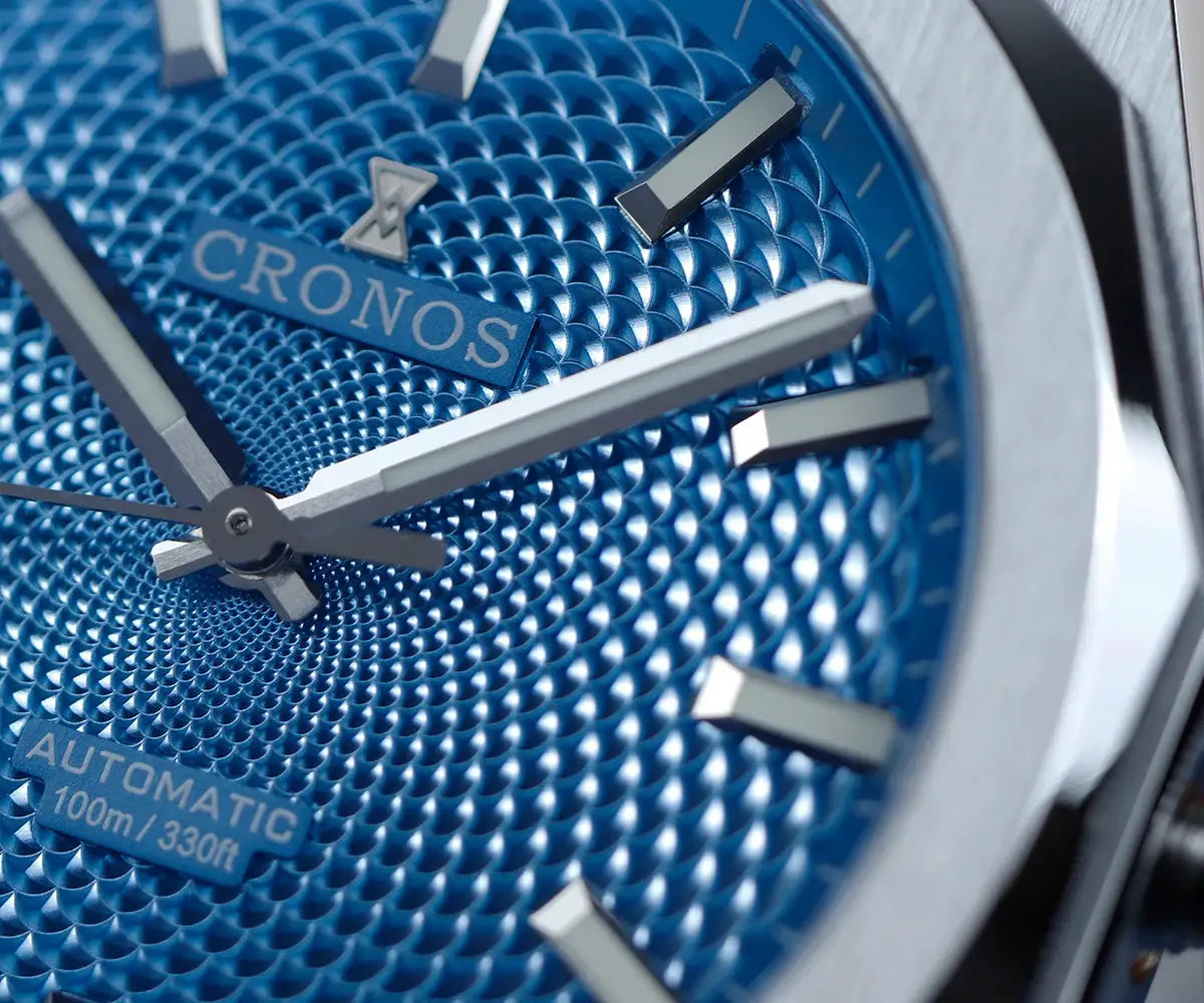 Cronos automatic wristwatch with blue patterned dial and stainless steel case, 100m water resistant.