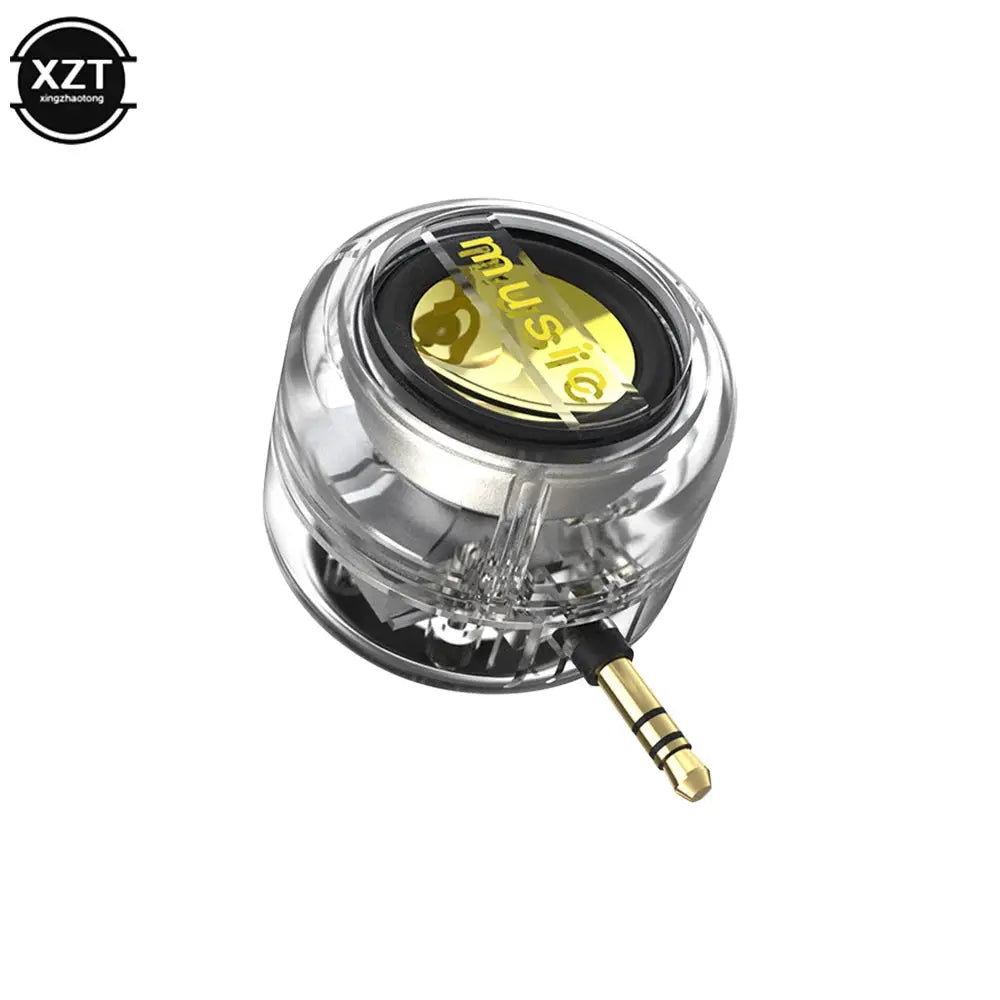 Speaker Simples Market portable mini speaker with transparent housing and gold 3.5mm plug; XZT logo visible