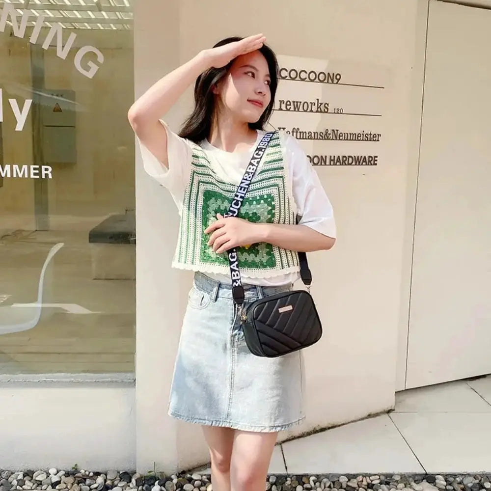 Shoulder bag Simples Market, black quilted PU crossbody with white text strap.