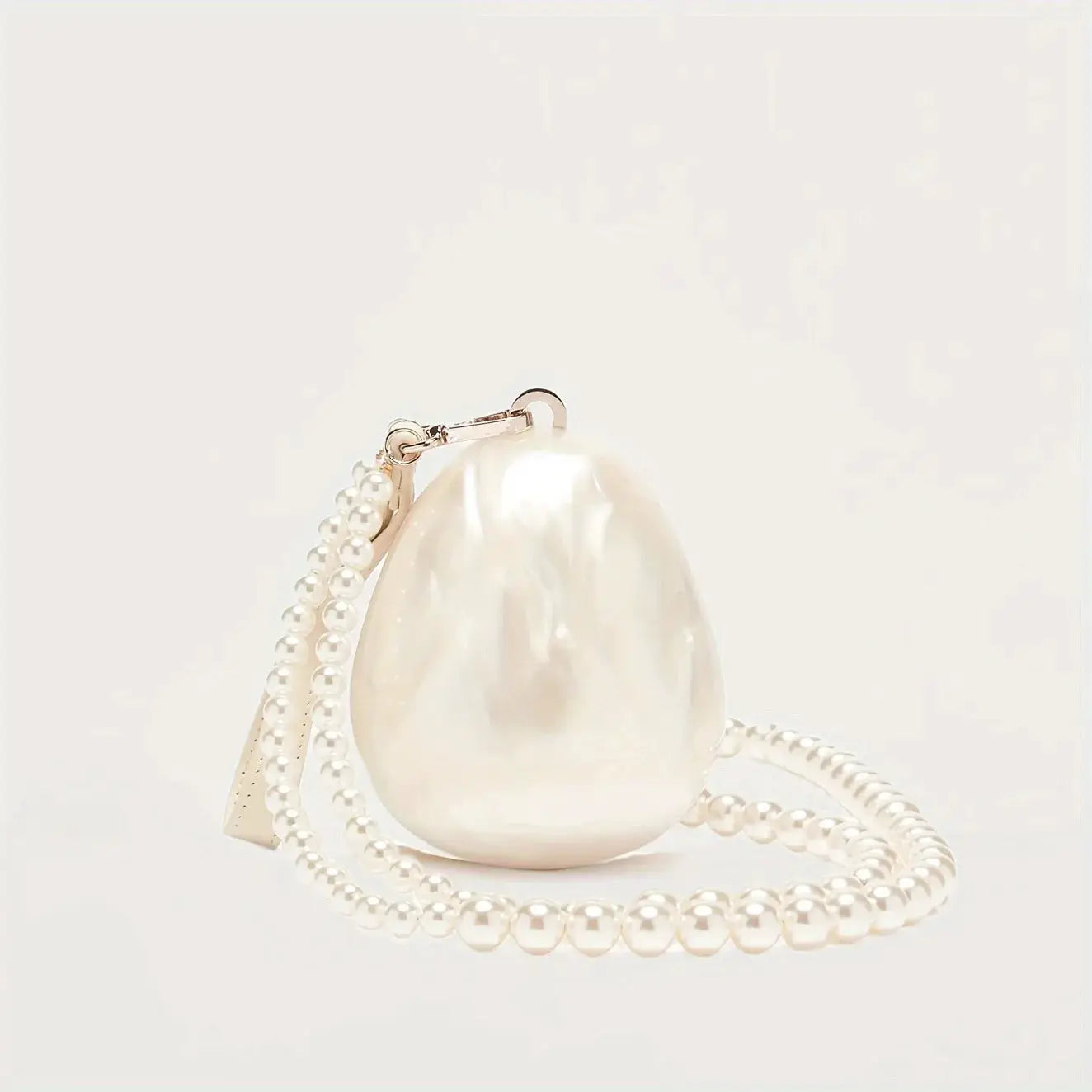 Egg-shaped pearl clutch bag with a beaded strap; ivory pearl purse for weddings.