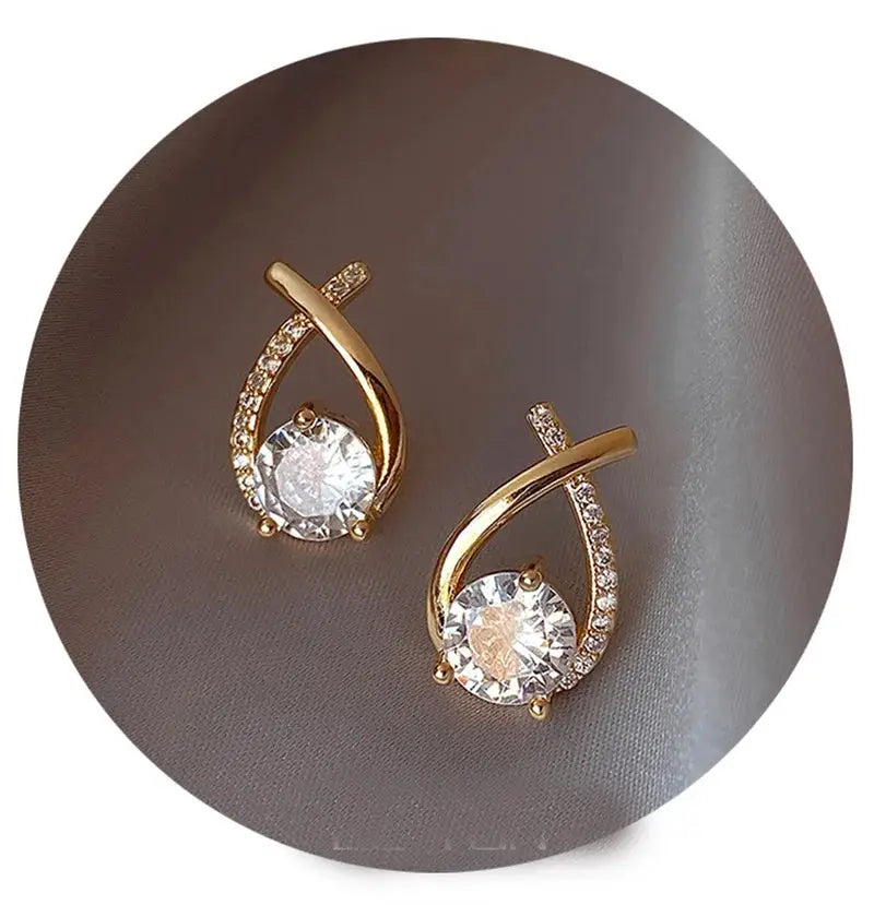 SKEDS gold-tone cross stud earrings, Simples Market pair with clear centerpiece crystals and pave-crystal arc