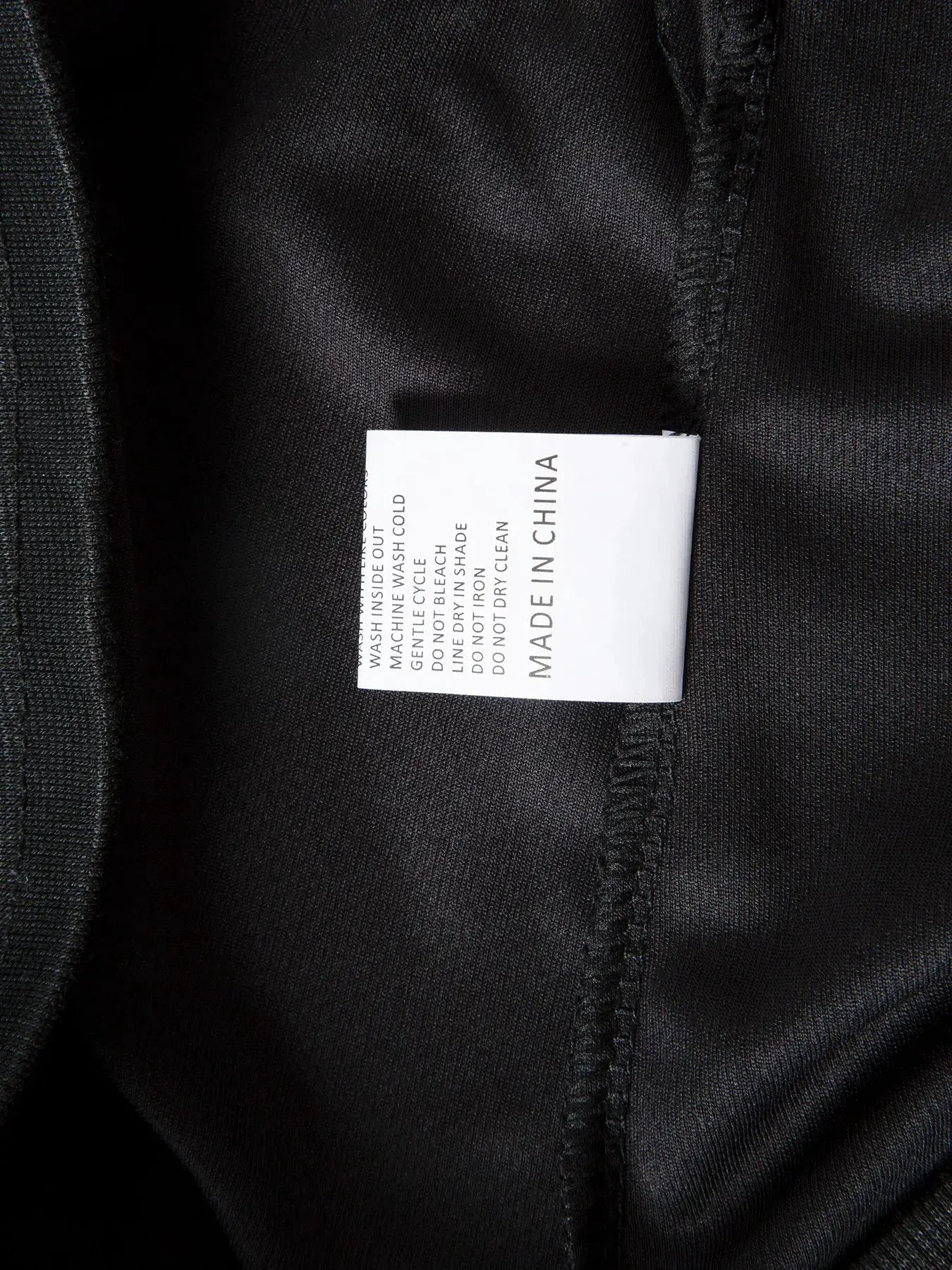 Men's black mesh gym shorts with quick-dry fabric; white care label inside waistband
