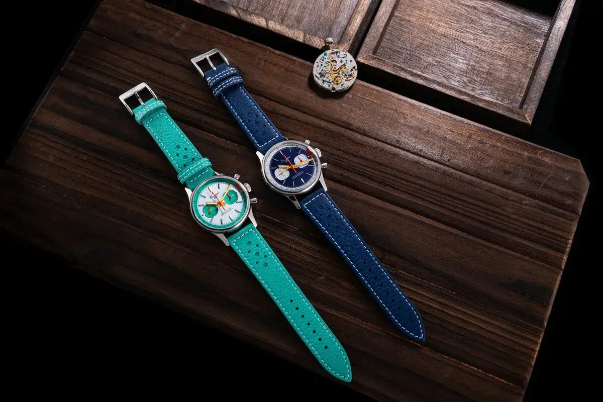 Sugess chronograph watches for men, two timepieces with turquoise and blue leather straps on a wooden surface