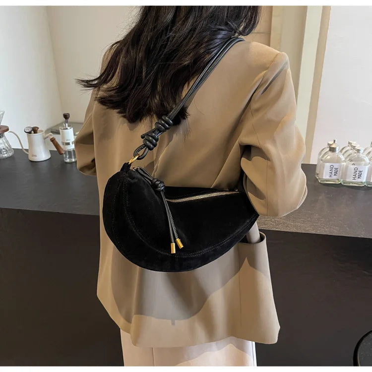 Faux suede shoulder bag, black, crossbody with knotted strap and tassel accents.