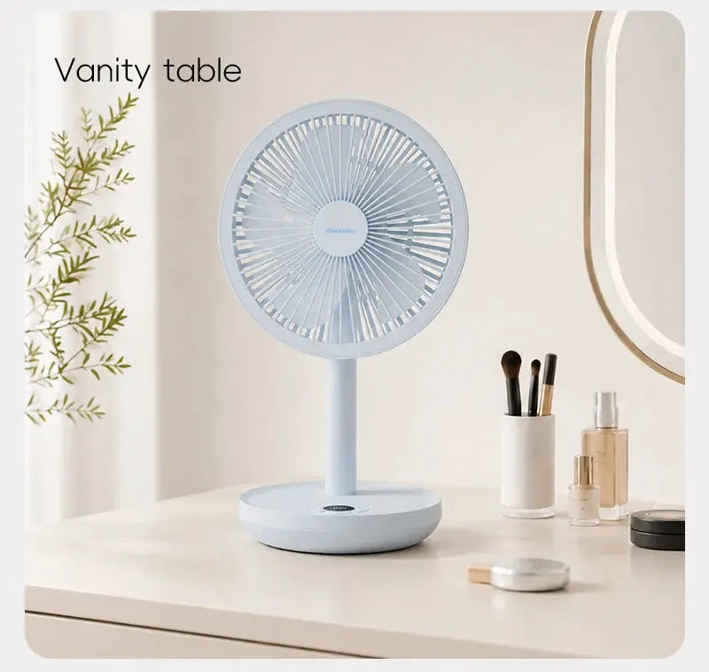 KINSCOTER desk fan in light blue on a vanity table beside makeup brushes and perfume bottles
