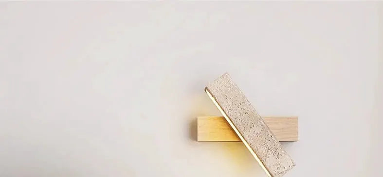 Natural stone wall lamp sconce with warm glow on a wooden block, modern minimalist decor