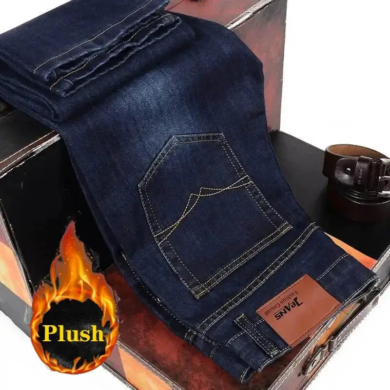 Blue denim jeans with back pocket and brown leather patch, folded over a wooden box