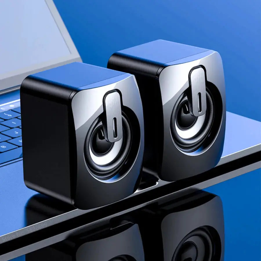 Desktop computer speakers, two blue-top units with silver fronts on a laptop