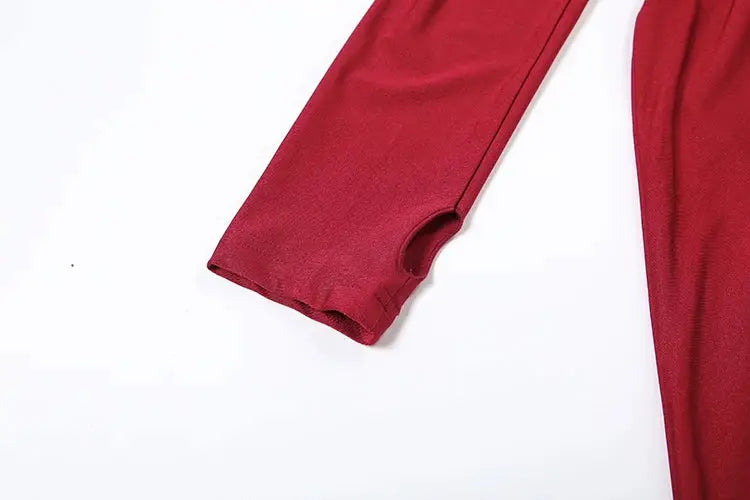 Jumpsuit sleeve detail in red knit fabric, partial view