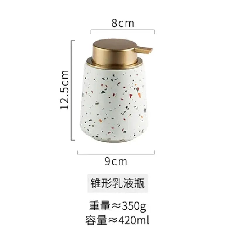 Terrazzo ceramic emulsion bottle by Simples Market with a gold pump, white speckled finish