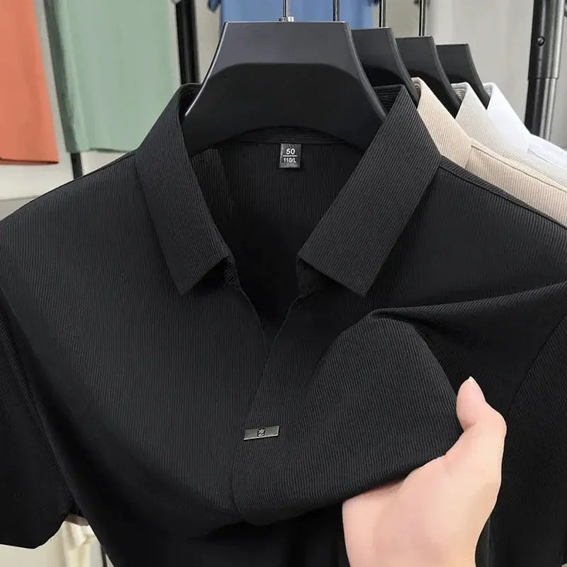 Black polo shirt by Simples Market, short sleeves, solid color with front metal logo badge