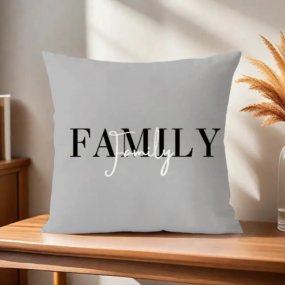 Gray decorative pillow cover featuring bold black FAMILY text with white Love script.