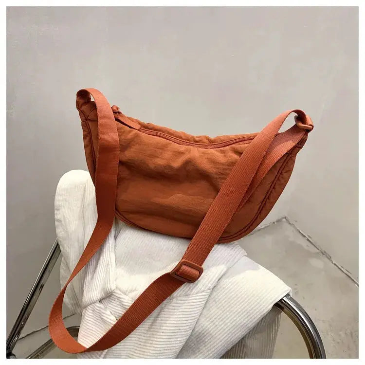 Casual nylon hobo crossbody bag in rust orange with adjustable strap and large capacity.
