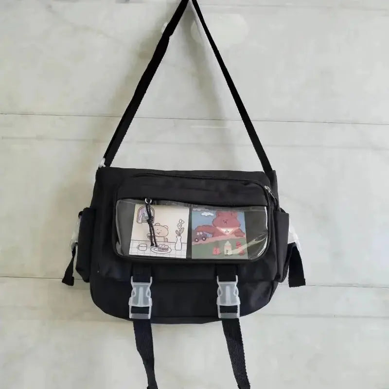 Large capacity canvas crossbody bag with front clear pocket displaying cartoon panels, black, Simples Market