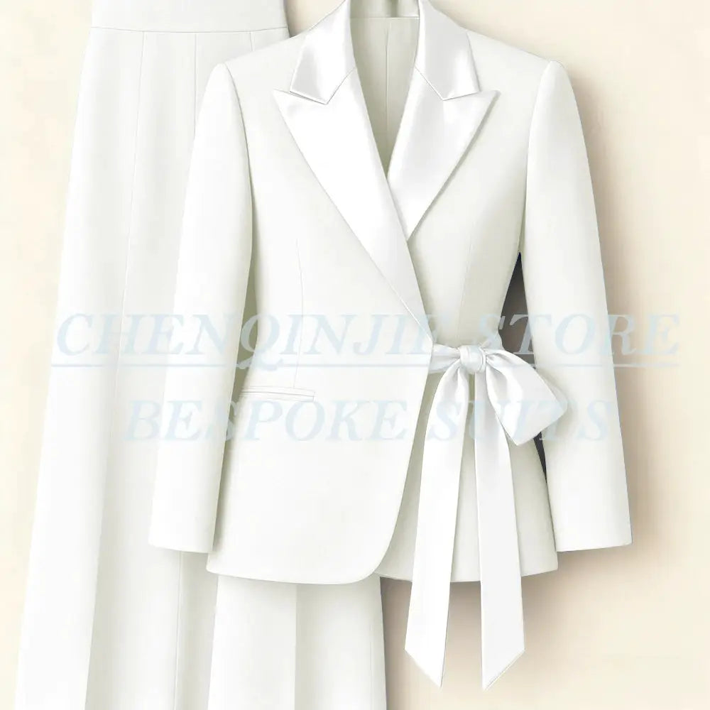 White women's two-piece blazer suit with peak lapels and waist tie, jacket plus trousers.