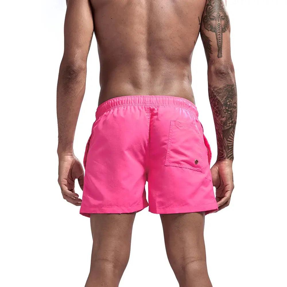 Pink men's swim trunks with elastic waistband and back pocket
