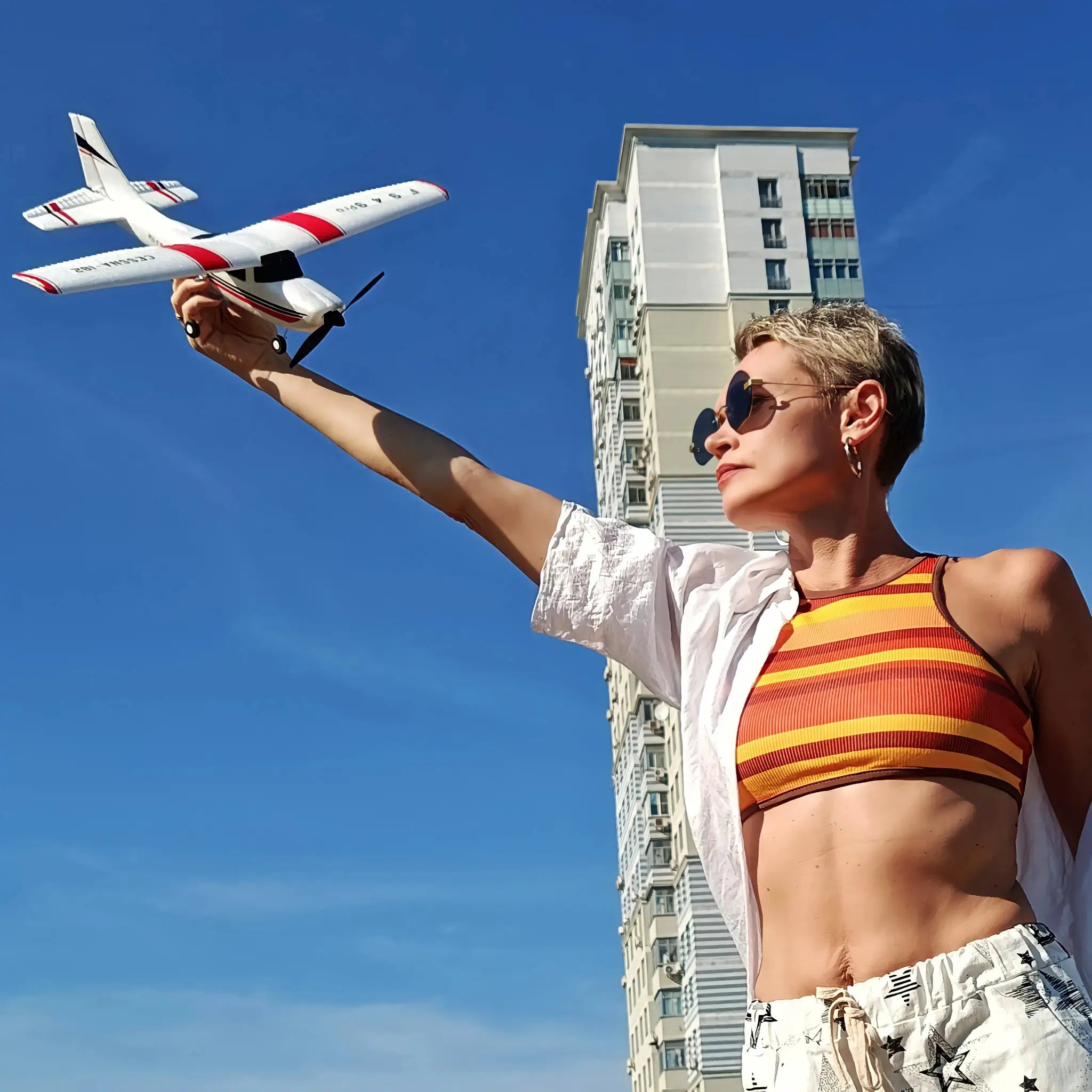 Simples Market WLtoys F949 LCD RC airplane held aloft, white with red accents against blue sky