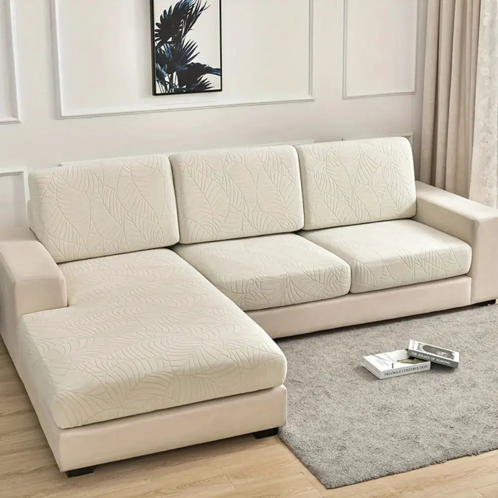 Waterproof stretch sofa cushion cover in jacquard leaf pattern on a beige L-shaped sectional couch with chaise