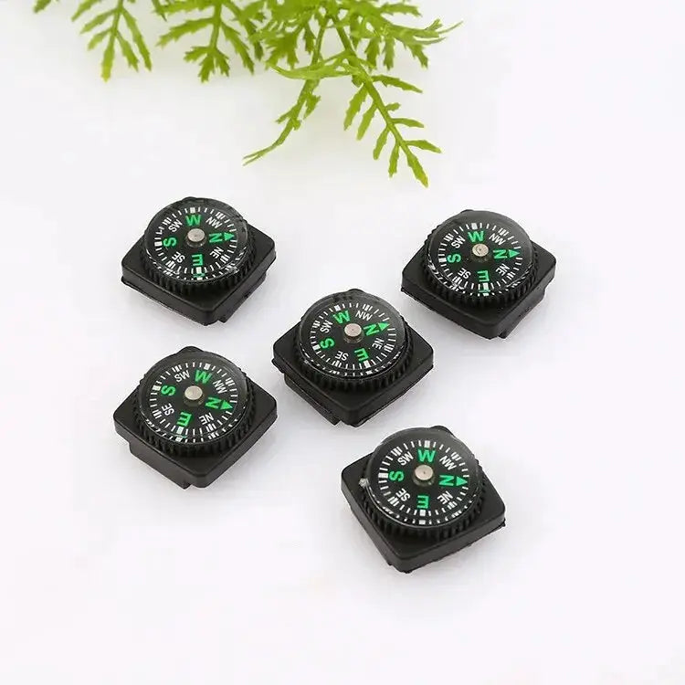 Five small black outdoor compasses with green dials on square bases for camping and mountaineering.