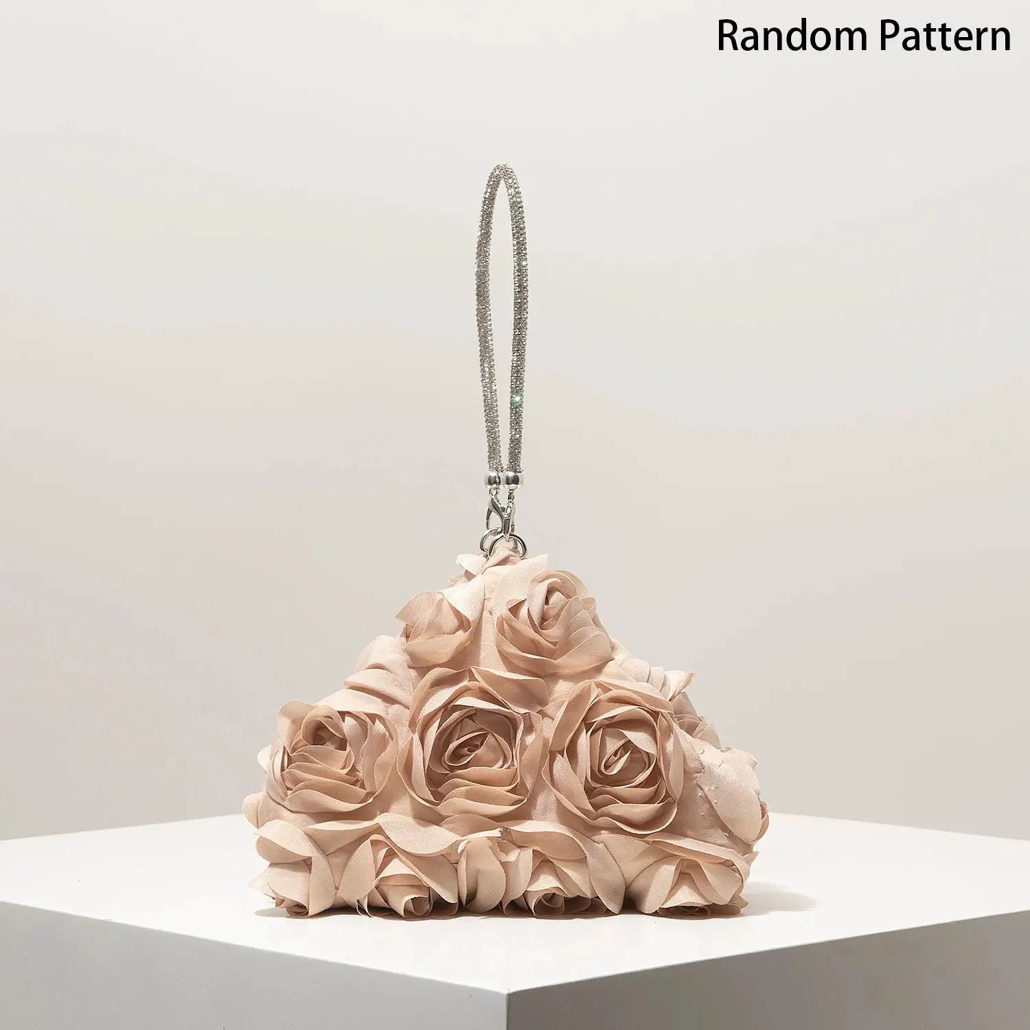 Mini purse with rhinestone beaded strap atop a pale pink rose-cluster clutch by Simples Market