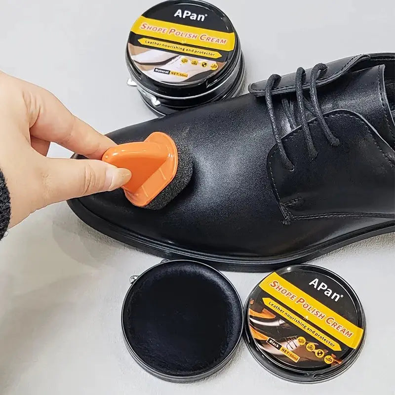 Faux leather shoe polishing kit; black leather shoe with orange applicator and APan shoe polish cream tins