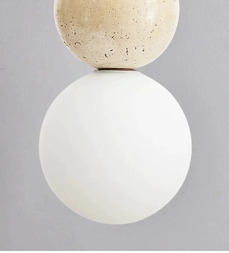 Cream style pendant lamp featuring a textured stone top ball and a large frosted white globe