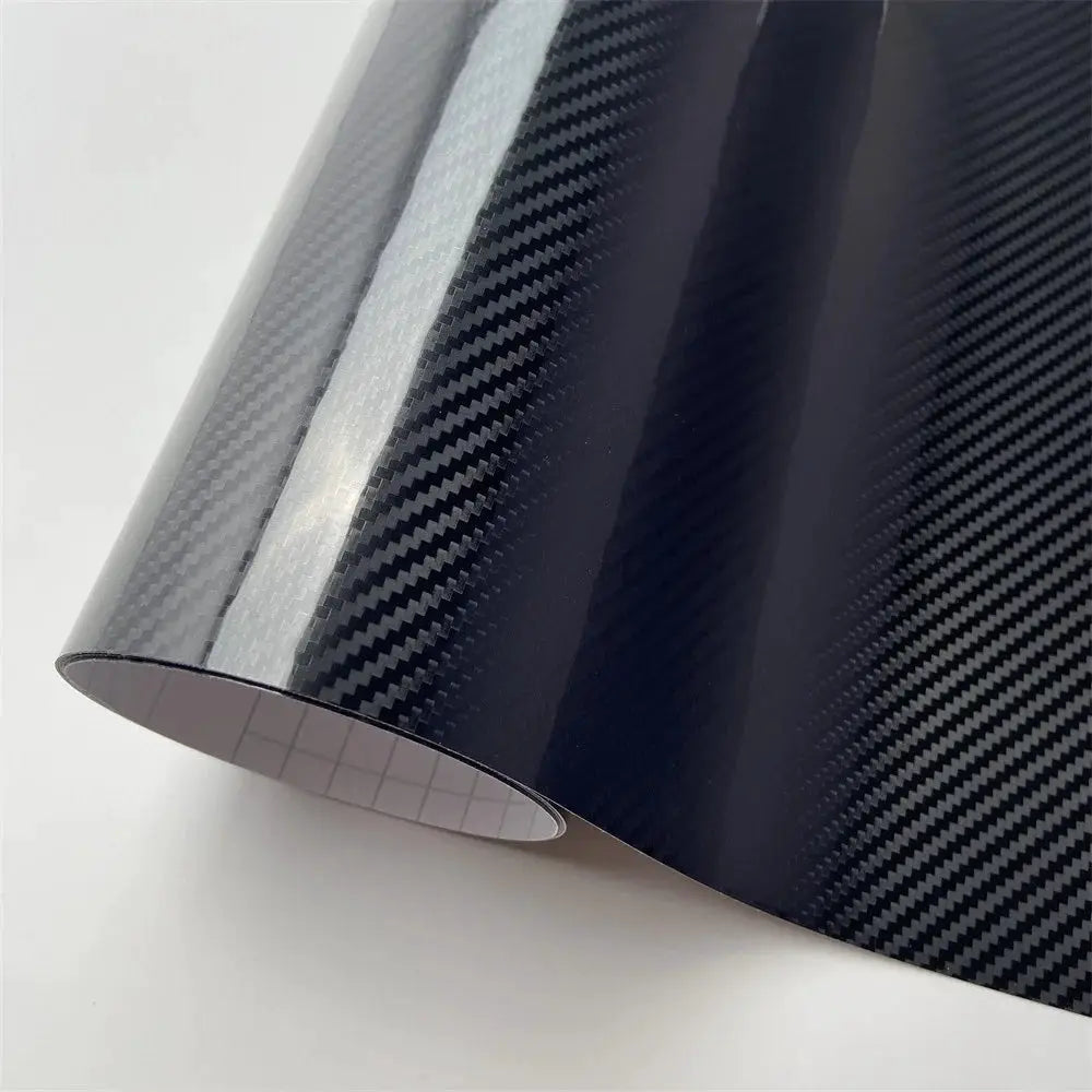 Black carbon fiber vinyl wrap roll with glossy finish and carbon weave pattern.