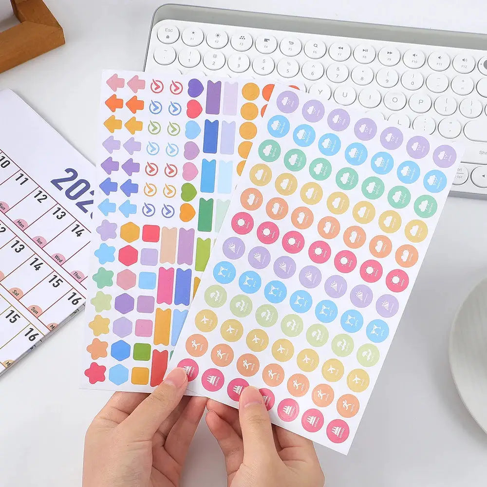 Three sheets of colorful calendar stickers for a 2026 wall calendar; rainbow round and geometric shapes
