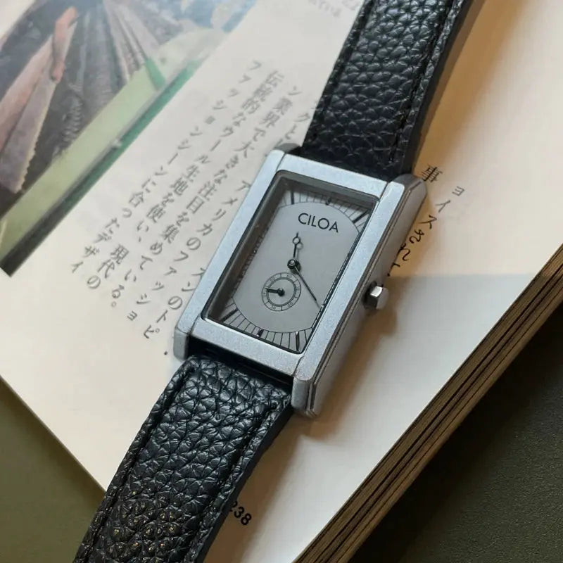 CILOA rectangular men's watch with silver case and black textured leather strap.