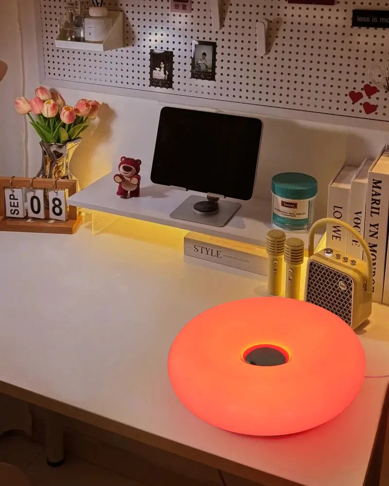 Bauhaus donut-shaped USB table lamp Simples Market with pink-orange glow on desk
