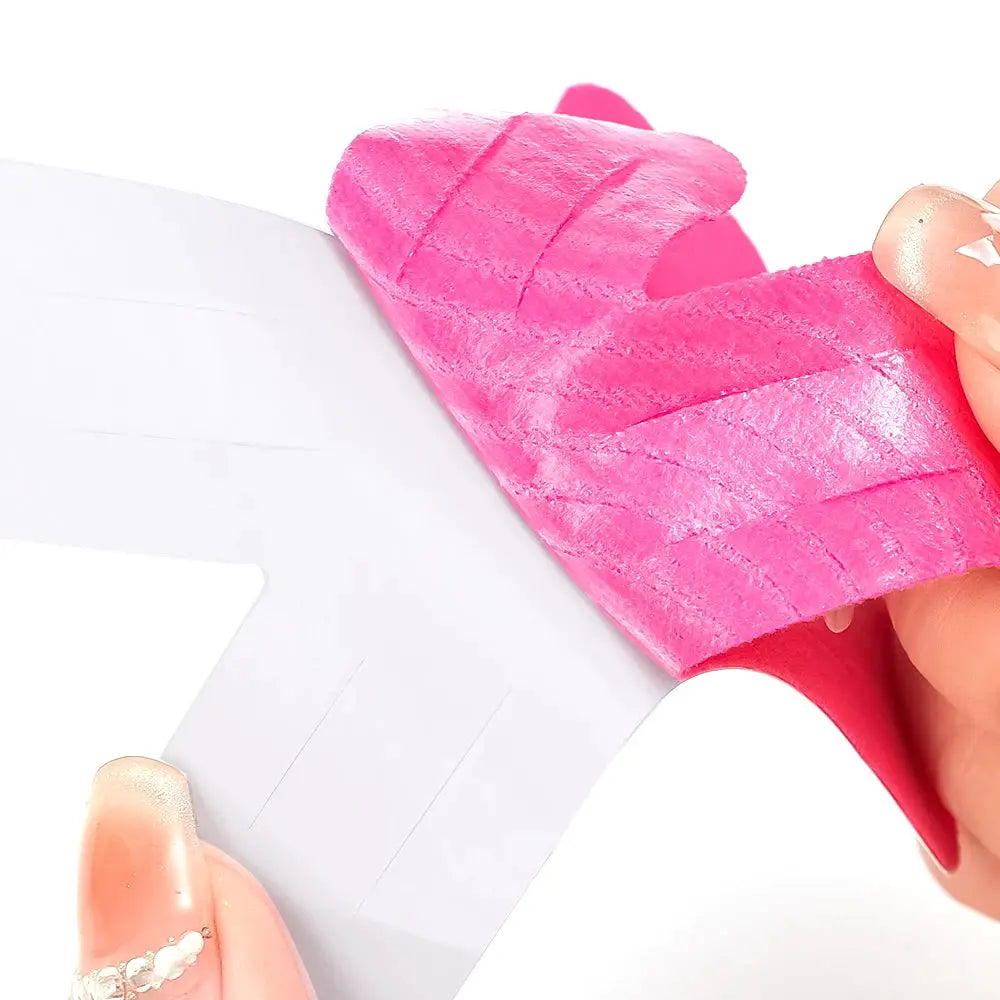 Kinesiology tape elastic therapeutic sports tape in pink, peeled from white backing.