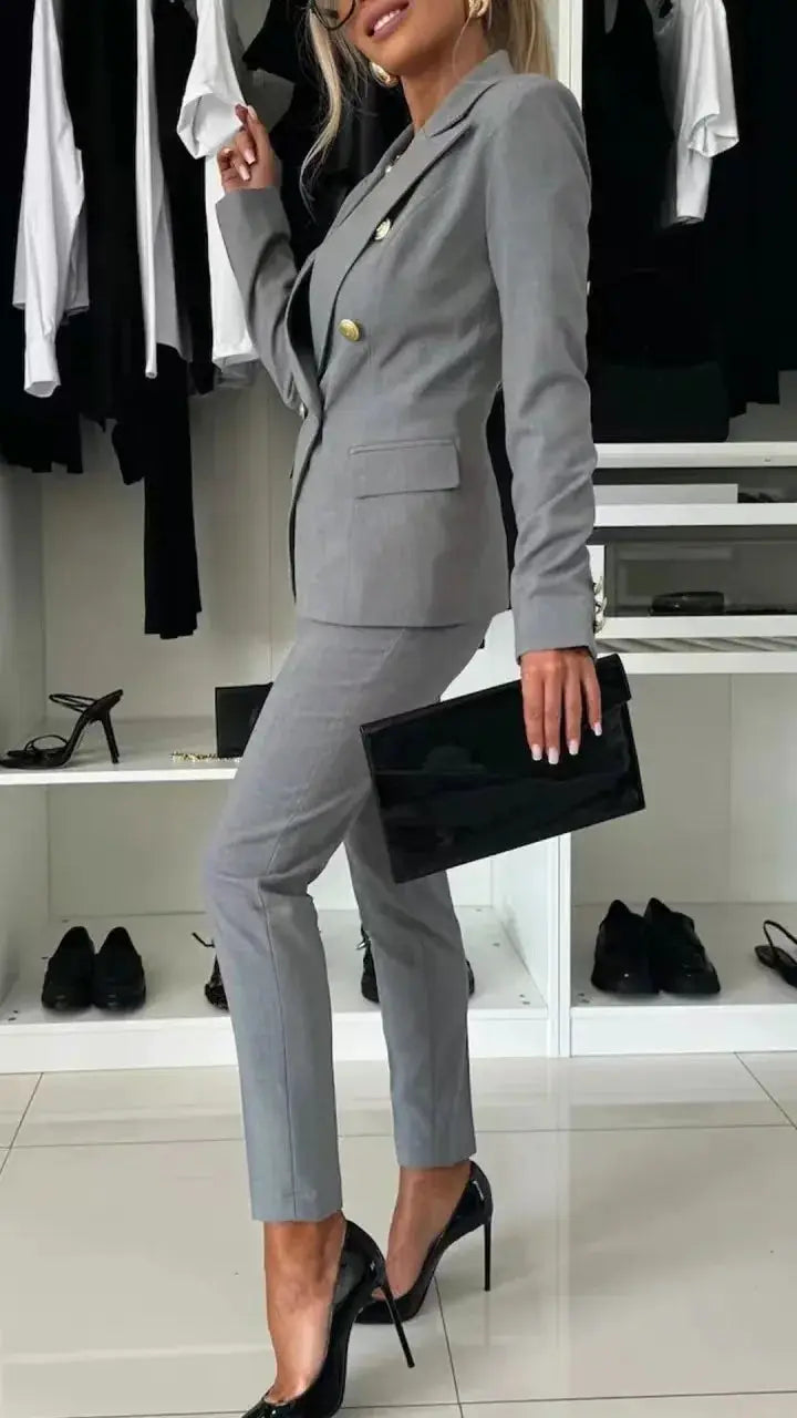 2-piece women's gray office suit by Simples Market; blazer with gold buttons and matching trousers.