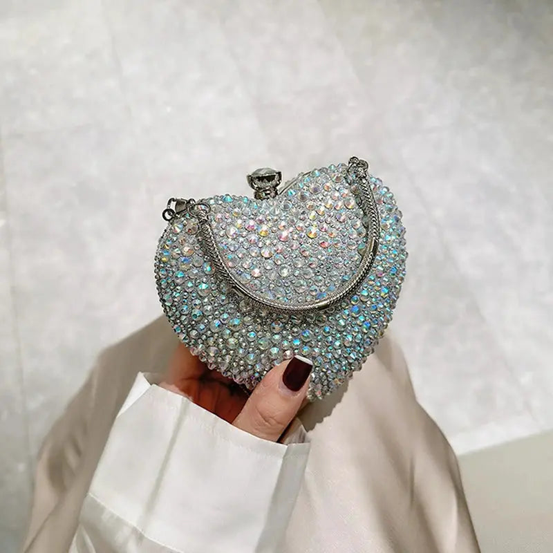 Heart-shaped crystal clutch purse by Simples Market with iridescent rhinestones and silver chain handle