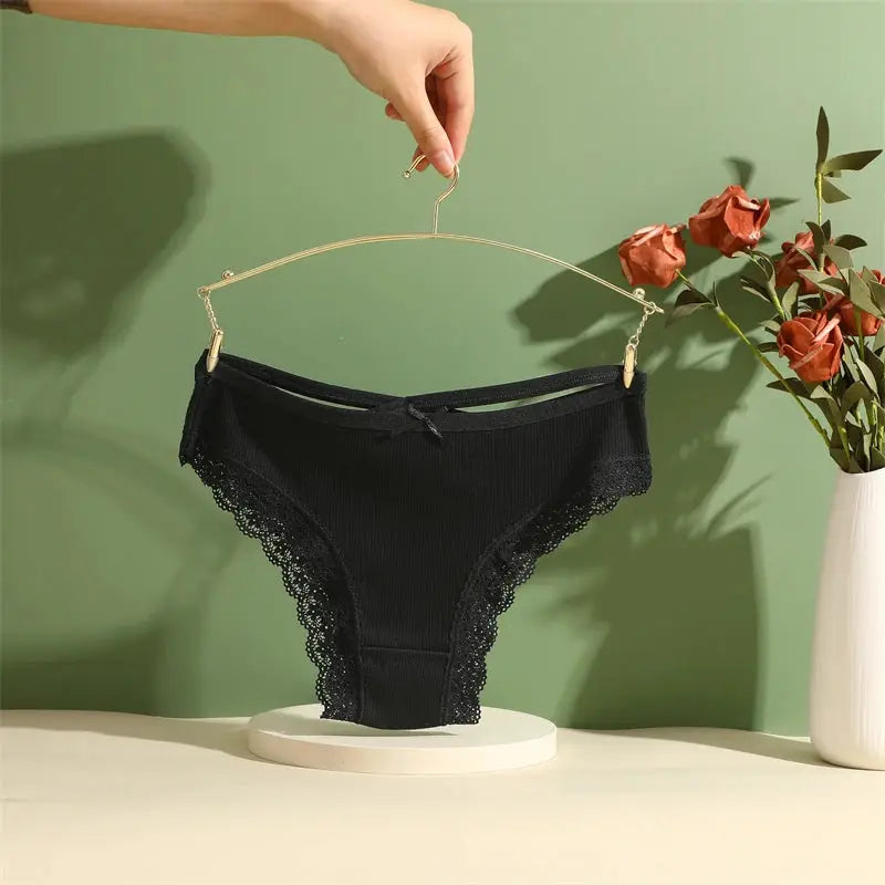 Cotton panties by Simples Market, black low-rise Brazilian briefs with lace trim, displayed on a hanger.