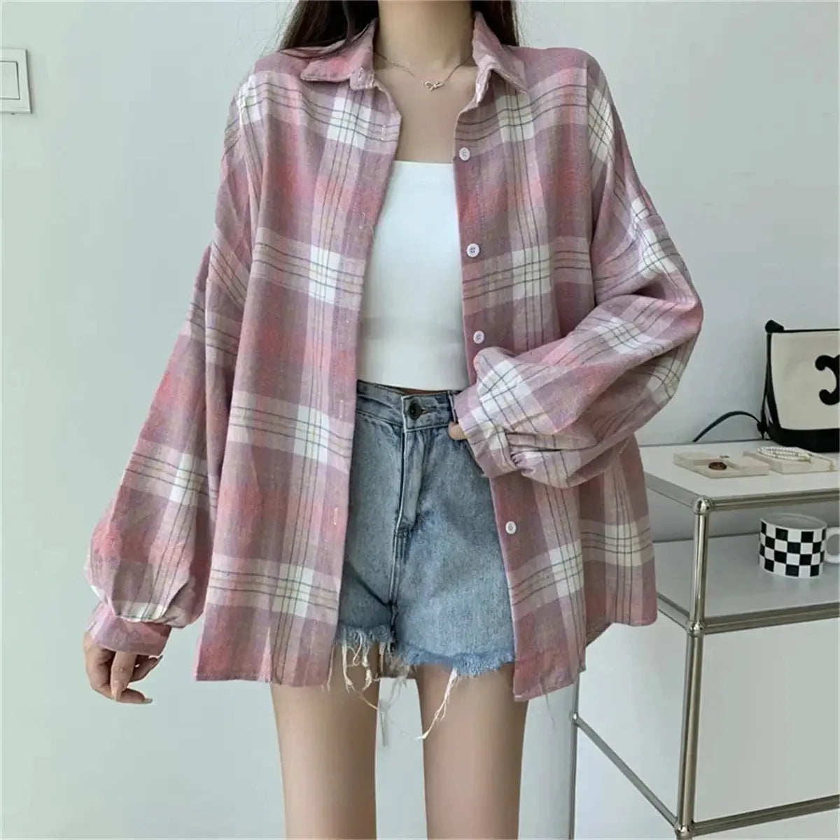 Pink plaid oversized long-sleeve shirt over a white top with frayed denim shorts, casual spring outfit
