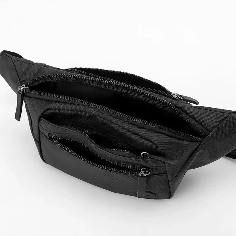 Unisex waterproof waist bag in black nylon with multiple zip pockets and adjustable strap