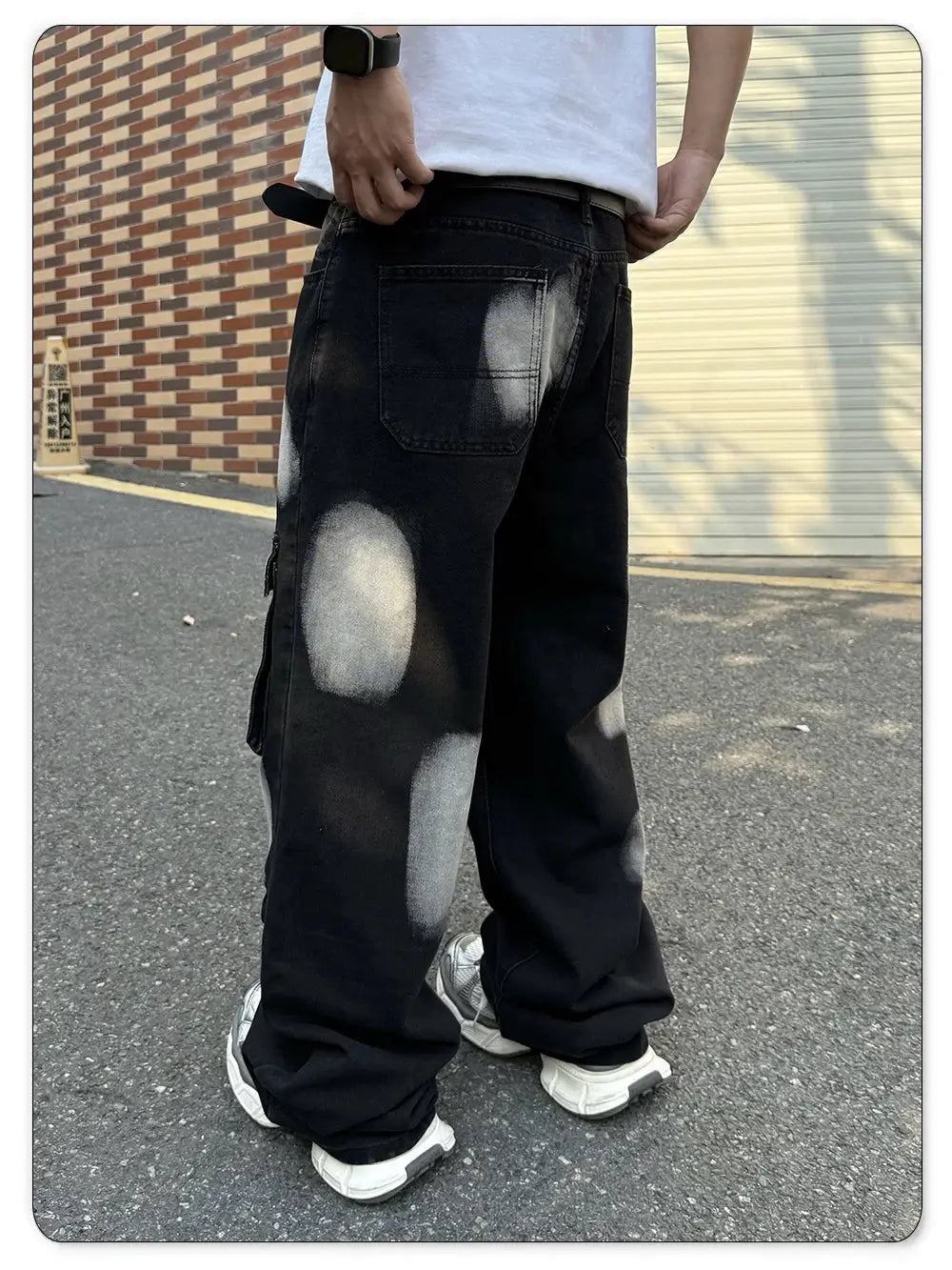 Men's black straight-leg workwear denim jeans with multiple pockets and paint-splatter patches