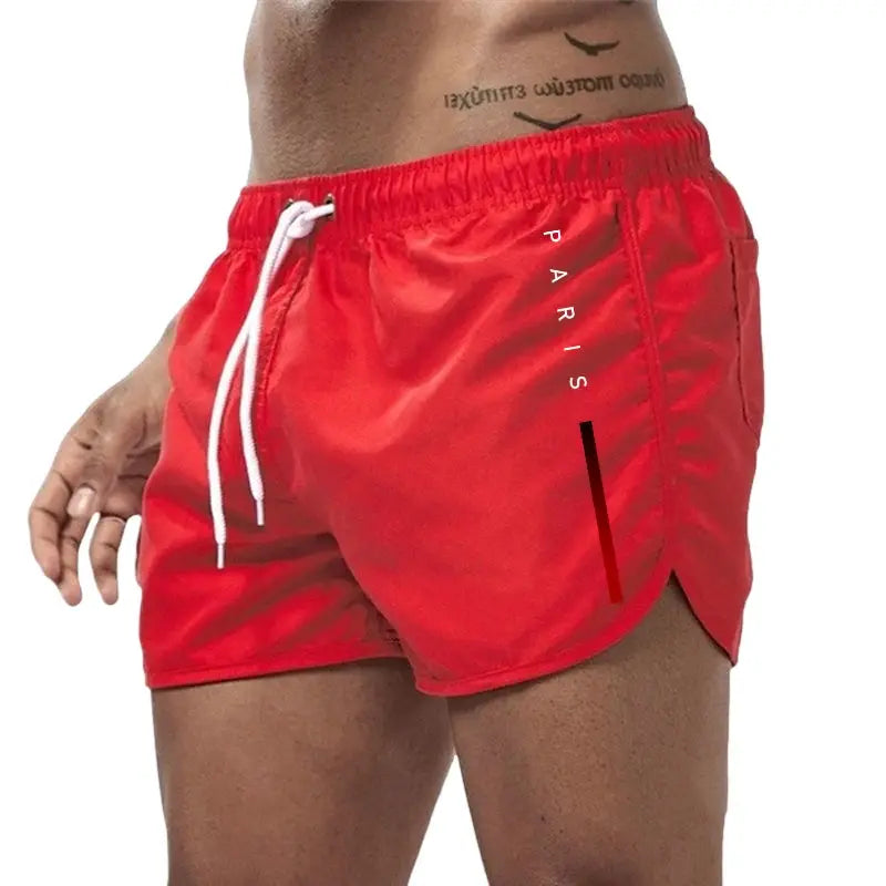 Men's red board shorts with white drawstring and Paris logo