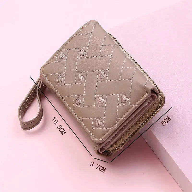 Women's PU leather tri-fold wallet with love pattern in beige, featuring zip closure and wrist strap