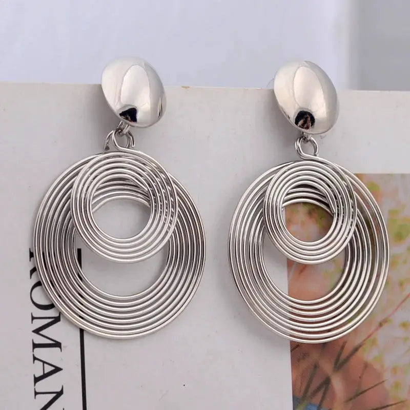 Pair of silver-tone big round statement earrings with nested concentric hoops, drop style