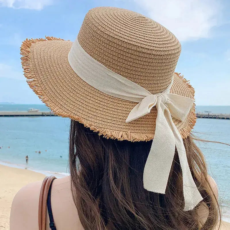Korean Bow Straw Hat for Women with a wide natural straw brim and a white ribbon bow.