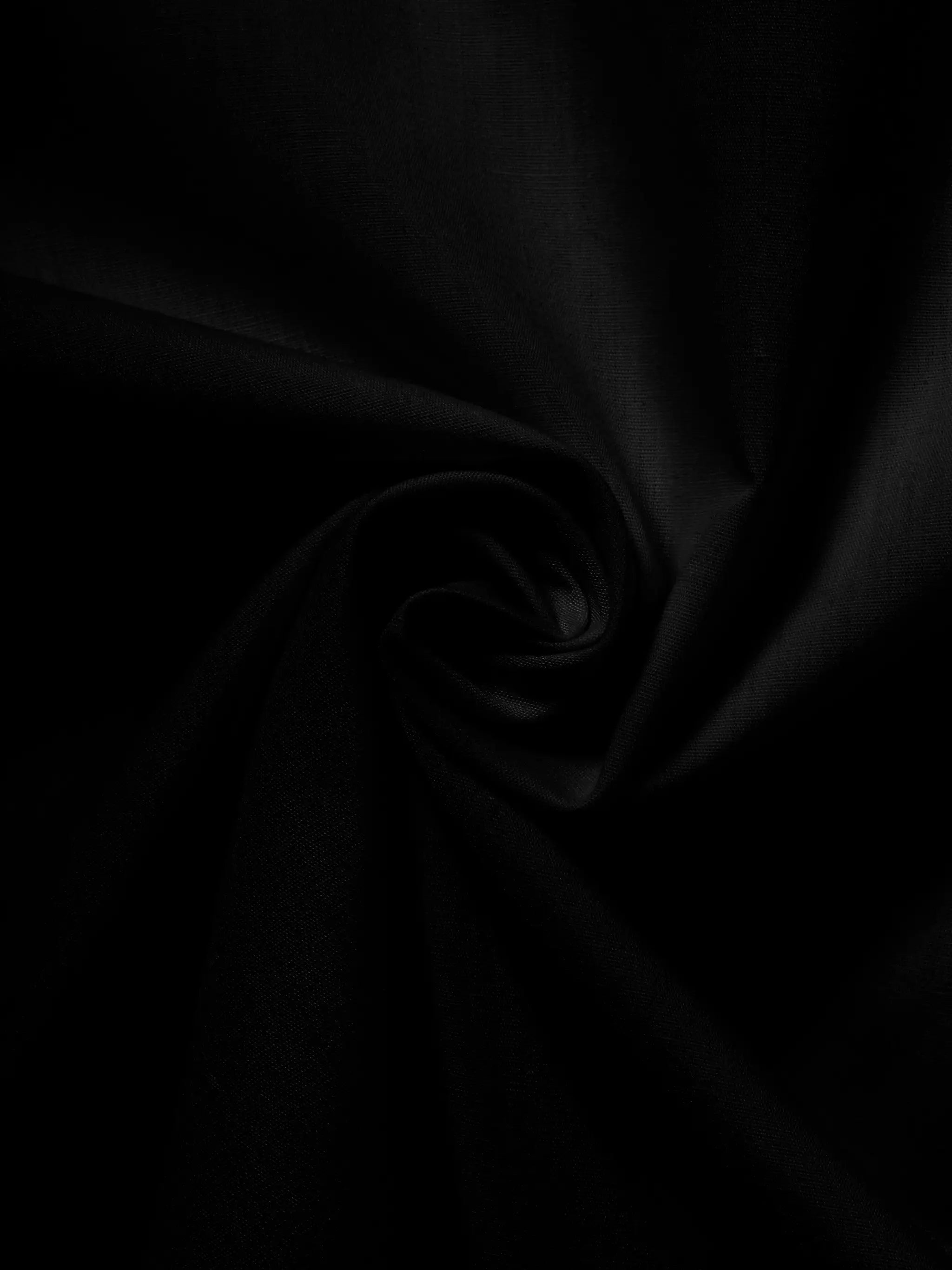 Men's black solid-color shirt fabric, close-up of draped cloth texture