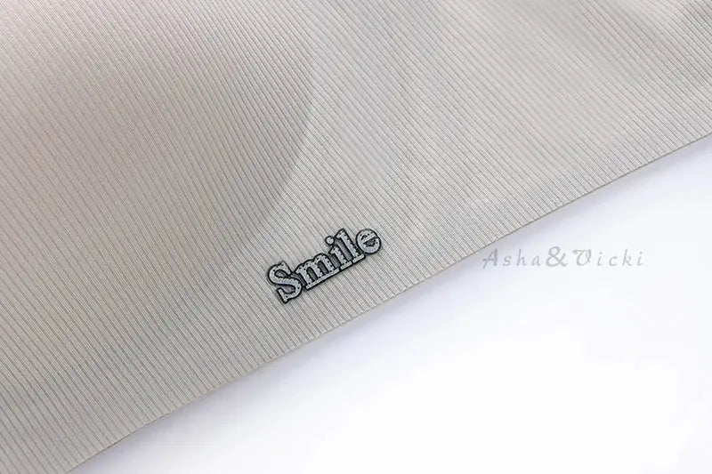 Underwear fabric swatch in beige with ribbed texture and Smile logo.