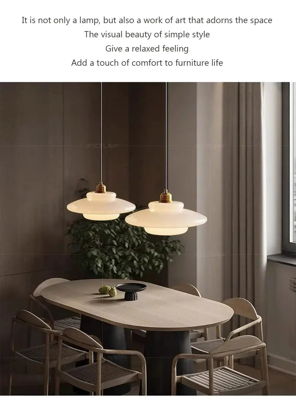 Nordic glass pendant lamps, two white frosted disks with brass fittings, hanging over a modern dining table.