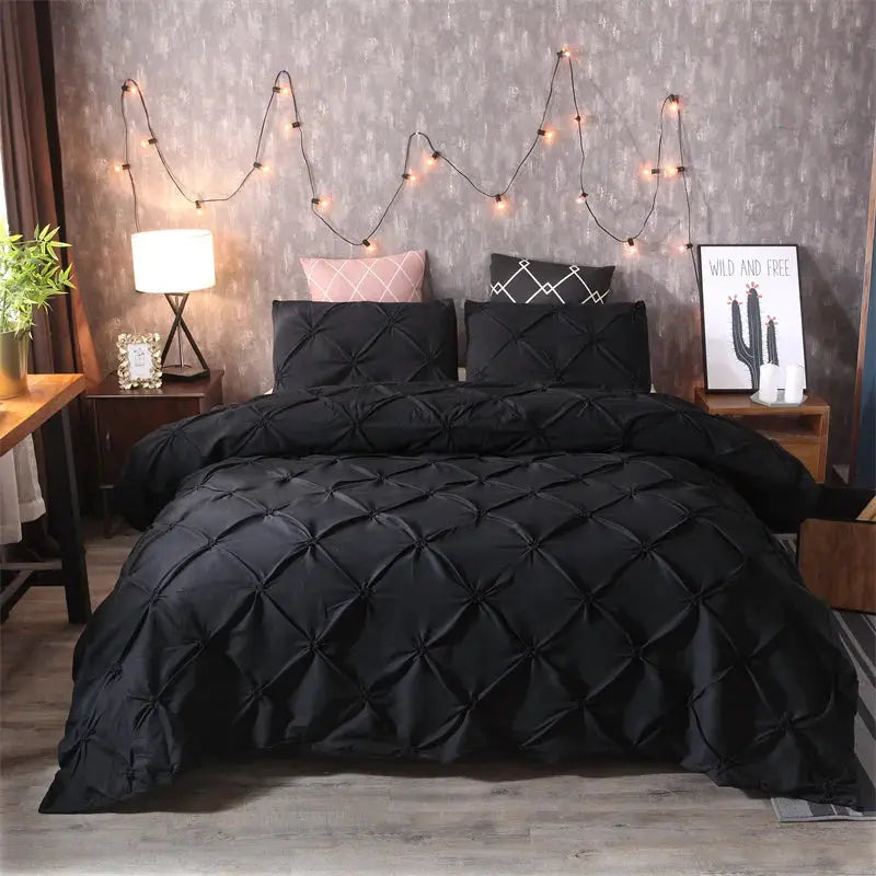 Queen 3-piece comforter set with black quilted duvet cover and pillowcases on a bed.