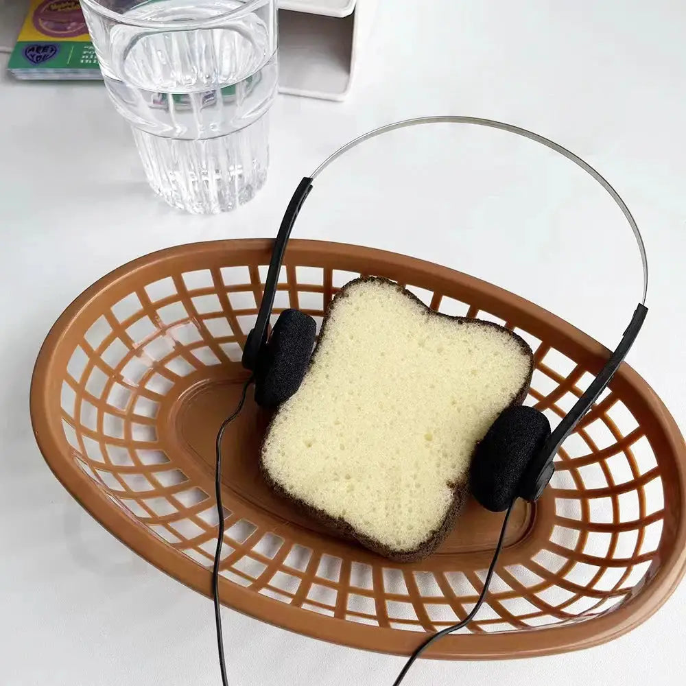 On-ear wired stereo headphones with adjustable headband and 3.5mm plug resting on white bread in a brown basket