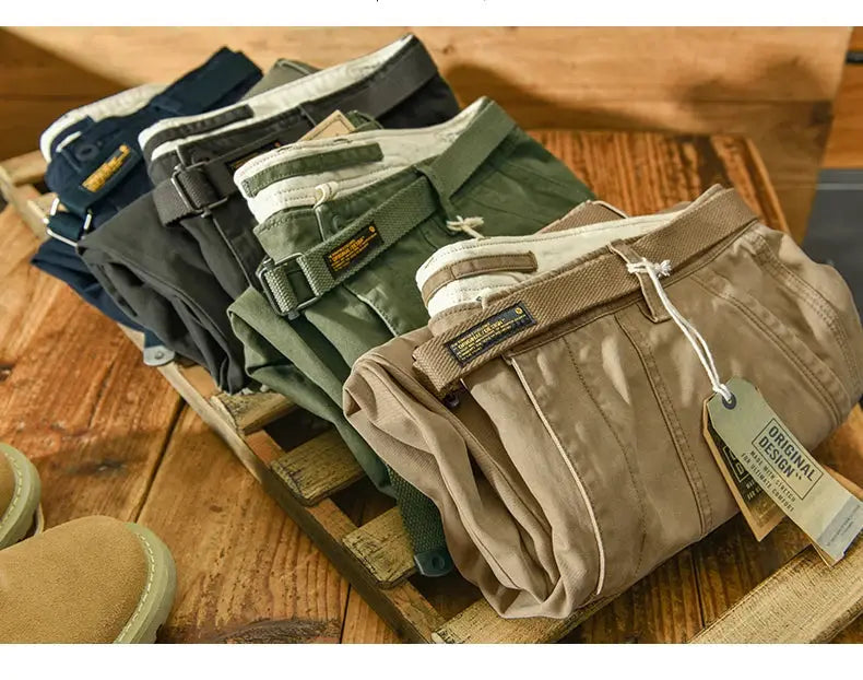 Men's cargo pants by Simples Market in six colors, six pairs displayed on a wooden surface.